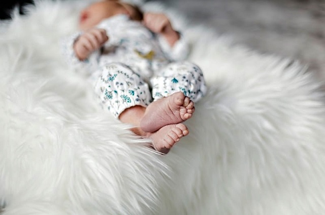 42 regalos para baby shower por menos de $25, a baby sleeping on a fuzzy white bed sheet.